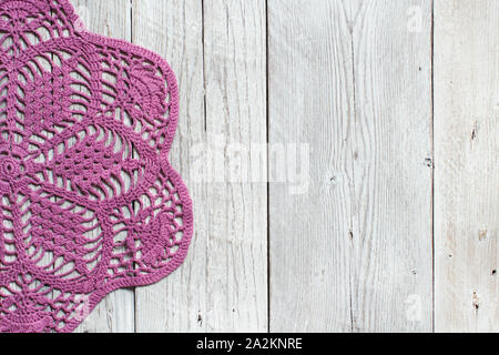 Napperon crochet rose sur la vieille table en bois Banque D'Images