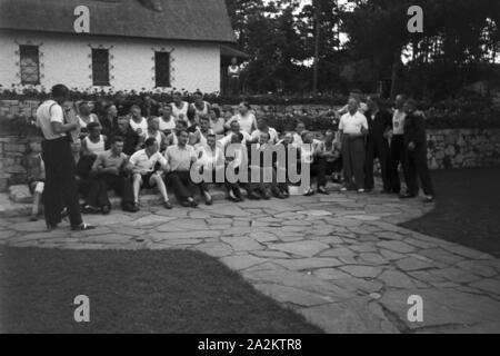 Musik und Tanz vor Waldhütten des KdF Sportheim Belzig dans der Mark Brandenburg, Deutschland 1930 er Jahre. Les gens chantent et dansent devant des cabanes dans la forêt au sports club à Belzig à Brandebourg, Allemagne 1930. Banque D'Images