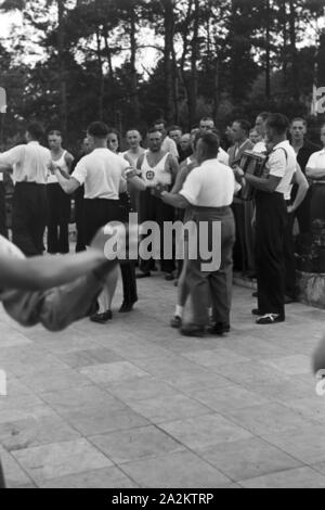 Musik und Tanz vor Waldhütten des KdF Sportheim Belzig dans der Mark Brandenburg, Deutschland 1930 er Jahre. Les gens chantent et dansent devant des cabanes dans la forêt au sports club à Belzig à Brandebourg, Allemagne 1930. Banque D'Images