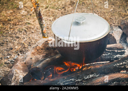 Chaudron fermé l'ébullition sur un feu de camp. Repas Camping Banque D'Images