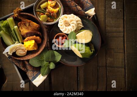 Nasi Timbel. Soundanais traditionnel fête de riz enveloppés dans des feuilles de banane ; servi avec plusieurs plats. Banque D'Images