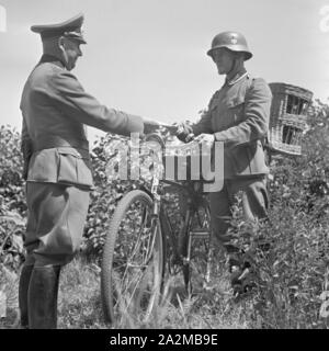 Original-Bildunterschrift Nachrichtentruppe Offizier : ein der übergibt einem Radfahrer der les Brieftaubenabteilung Überbingung Brieftauben zur durch die Deutschland, avant 1940er Jahre. Un officier du corps du signal donnant un message pour le cycliste du pigeon voyageur pour l'unité de la transmettre via la ligne de pigeon, l'Allemagne des années 40. Banque D'Images