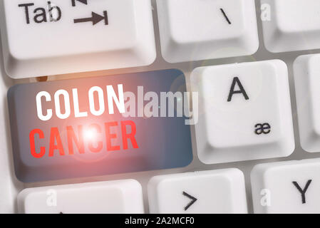 Texte de l'écriture d'un cancer du côlon. Photo conceptuelle du développement des cellules de cancer du côlon ou du rectum avec clavier pc blanc note de papier au-dessus de vide Banque D'Images