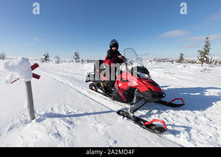 Moottorikelkkailua hangella Lapissa talvella. Nainen ajaa. Banque D'Images