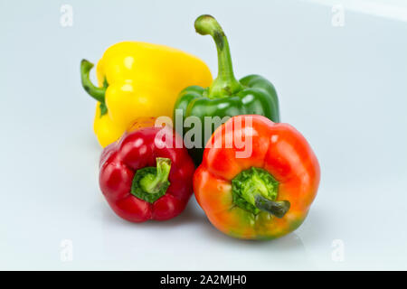 Vert, rouge et jaune sur le tableau blanc capsicums avec fond blanc Banque D'Images