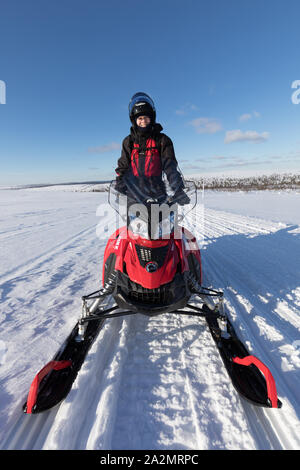 Woman driving motoneige à l'hiver arctique Laponie wonderland Banque D'Images