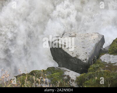 Un grand morceau de basalte se bloque de manière précaire sur le bord de Dettifoss, la plus grande cascade de l'Islande. Banque D'Images