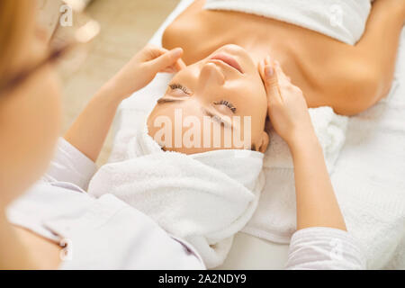 Massage du visage d'une belle fille dans une clinique de beauté. Banque D'Images
