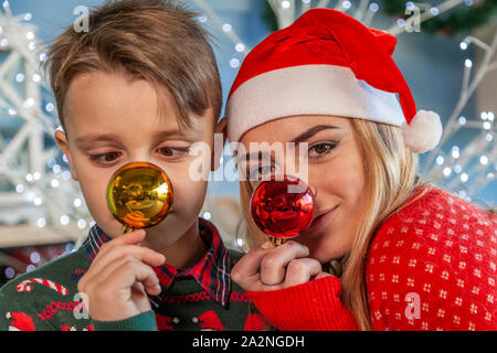 Frère et sœur s'amuser faire des grimaces avec des boules de Noël Banque D'Images