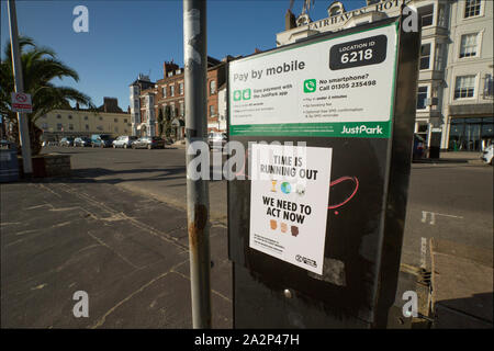 Une extinction de l'affiche de la rébellion, ou circulaire, placé sur un parcomètre sur front de mer de Weymouth. Il appelle le gouvernement à lutter contre le changement climatique et d'adv Banque D'Images