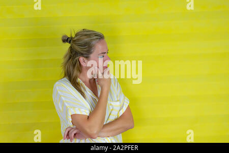 Beau young hispanic woman wearing stripes shirt with hand on chin pense à question, pensive expression.doute concept Banque D'Images