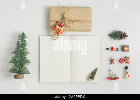 Boîte cadeau fait main et maquette d'ordinateur portable avec les boules de Noël sur fond blanc Banque D'Images