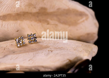 Belles boucles d'oreilles diamant sur pierre avec surface noire Banque D'Images