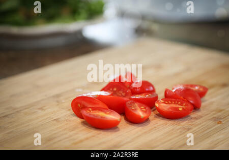 Les tomates sur une planche à découper. Tomates cerises rouges mûres sur planche de bois Banque D'Images