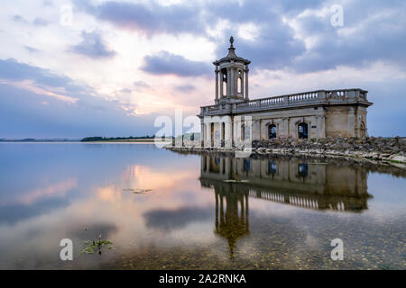 Normanton Church se reflète dans une calme Rutland Water au coucher du soleil un soir d'été, l'étage inférieur caché sous le réservoir. Banque D'Images