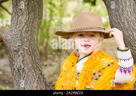 Girl holding chapeau brun sur la tête. Banque D'Images