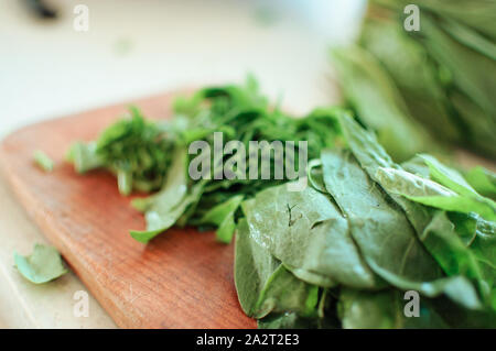 Les jeunes tranches d'oseille verte pour le borscht et salade se trouve sur une planche à découper, de style rustique, le matin dans la lumière du soleil. Copier l'espace. Banque D'Images