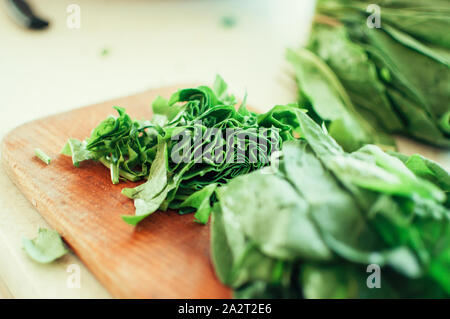 Les jeunes tranches d'oseille verte pour le borscht et salade se trouve sur une planche à découper, de style rustique, le matin dans la lumière du soleil. Copier l'espace. Banque D'Images