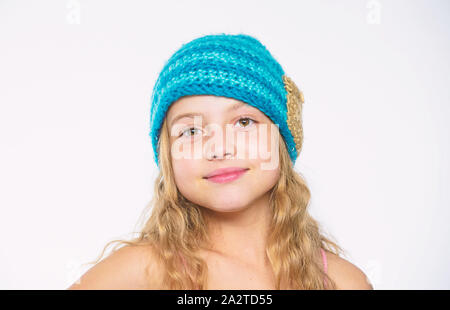 Usure Kid blue hat tricoté doux chaleureux. Différence entre le tricot et crochet. Modèles de tricot gratuit. Saison Automne Hiver accessoire. Chapeaux tricotés pour enfants. Des cheveux longs de fille heureux face fond blanc. Banque D'Images