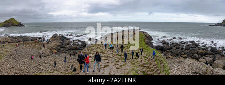 Les touristes, grimpant sur la colonnes de basalte de la Chaussée des Géants en Irlande du Nord Banque D'Images