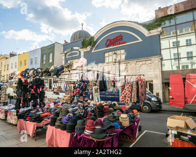 Chapeaux à vendre sur un marché sur la route de Portabello, Notting Hill, Londres.Behind est la façade bleue du cinéma électrique. Banque D'Images