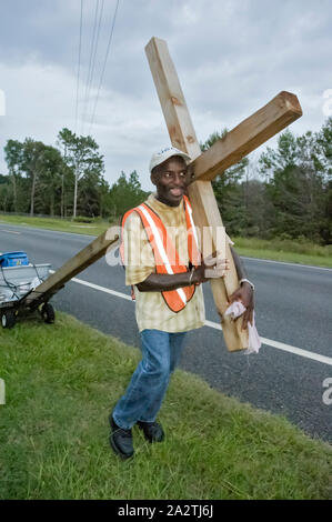 Homme portant une croix géante le long d'une autoroute dans le Nord de la Floride. Banque D'Images