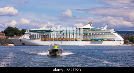 OSLO, Norvège - Petit bateau en face de l'explorateur de la mer, un navire de croisière Royal Caribbean, amarré au bord de la forteresse, Oslo. Banque D'Images