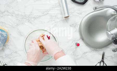 Étape par étape. Mise à plat. Le mélange colorant alimentaire dans la pâte à biscuits à cuire, rouge, blanc et bleu sucre pinwheel cookies. Banque D'Images