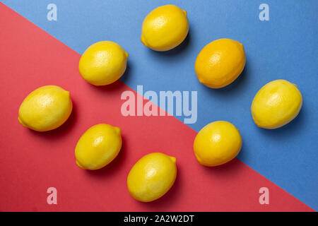 Citrons sur le bicolor rouge et le fond bleu. Mise à plat d'agrumes. Concept géométrique. Banque D'Images