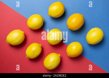 Citrons sur le bicolor rouge et le fond bleu. Mise à plat d'agrumes. Concept géométrique. Banque D'Images