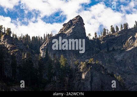 Formations granitiques en forme d'un ours avec des pins entourant et ciel bleu dans la vallée de Yosemite, Californie Banque D'Images