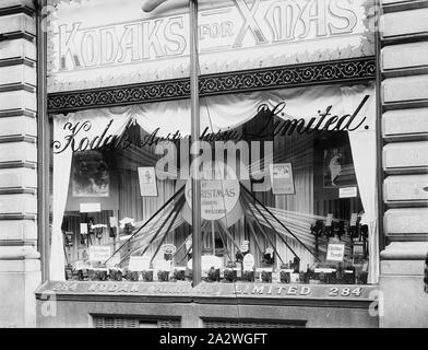 Négatif sur verre - Kodak Australasia Ltd., Noël Shopfront Afficher, Block Arcade, 284 Collins Street, Melbourne, 1911 - 1920, Noir et blanc, Négatif sur plaque de verre du Kodak Australasia limitée des passants dans Block Arcade, 284 Collins Street Melbourne, vers 1911 à 1920. L'affichage dispose de plusieurs caméras, a souligné que "présente" et d'une tétine sunburst faites d'un matériau avec un signe circulaire dans le centre de dire 'un Kodak à Noël est toujours la bienvenue Banque D'Images