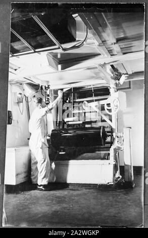 Négatif sur verre, homme employé d'usine avec la machine, vers 1939, Noir et blanc, trimestre négatif de la plaque d'un homme employé d'usine exploitation d'une grande film bobineuse dans ce qui est probablement l'usine Kodak Australasia Pty Ltd à Abbotsford, vers 1939. collection de produits, de matériel publicitaire, photographies et objets de la vie active, lorsque l'usine de fabrication à Melbourne Banque D'Images