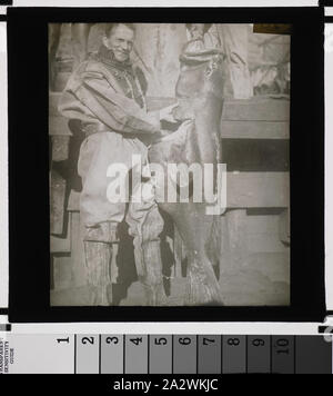 Diapositive - Homme en combinaison de plongée avec des poissons, vers 1920, diapositive sur Noir et blanc avec une photo d'un homme dans une combinaison de plongée (casque enlevé) avec un gros poisson. Il semble être lié à deux autres photographies prises dans le Pacifique Banque D'Images