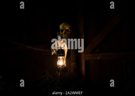 Droitwich Spa, Worcester, England, United Kingdom, 02/10/2019, Ghost tours, squelette tenant une lampe à huile allumée contre une structure en bois dans la nuit. Hallo Banque D'Images
