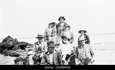 Négatif - groupe de huit hommes et femmes assis sur des pierres sur la plage, Torquay, Victoria, vers 1930, un groupe de huit hommes et femmes assis sur des pierres sur la plage Banque D'Images