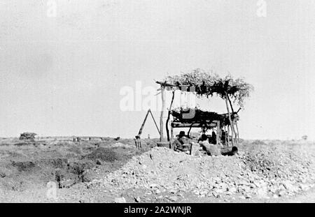 - Négatif, Tanami Territoire du Nord, 1937, un groupe d'hommes dans un abri construit sur une fourmi lit. Le refuge est constitué de broussailles sur une plate-forme prise en charge à chaque coin par branches. Il y a un trépied dans la distance Banque D'Images