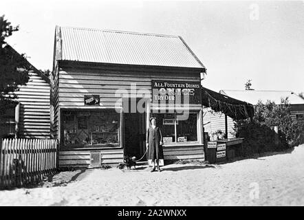 - Négatif Inverloch, Victoria, 1930, une femme avec un chien debout devant un magasin. C'était un thé le matin et boutique de confiseries ainsi qu'une résidence Banque D'Images