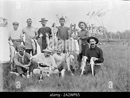 Négatif - Mount Morgan, Queensland, vers 1910, un groupe d'hommes avec leurs prises de poissons. Un homme est servir la bière ( ?) dans une tasse Banque D'Images