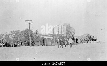 Négatif - District de Swan Hill, Victoria, vers 1920, quatre hommes marchant dans la rue dans une ville Banque D'Images