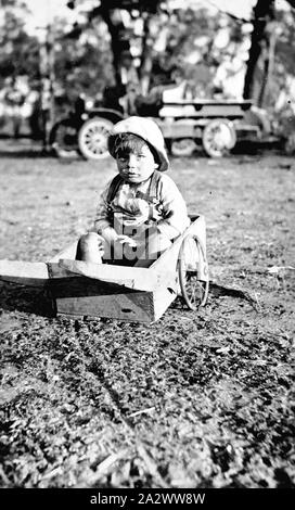 Négatif - District de Mildura, Victoria ( ?), vers 1920, un enfant dans un panier à la main. Il y a un camion à l'arrière-plan Banque D'Images