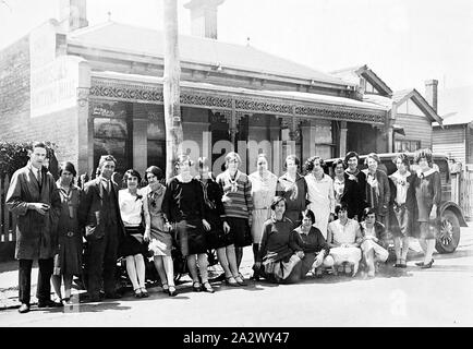 Négatif - Melbourne, Victoria, en 1922, le personnel de Harrison's Knitting Mills se sont réunis dans la rue. Il y a une voiture derrière eux qui est garé à l'extérieur d'une maison de banlieue Banque D'Images