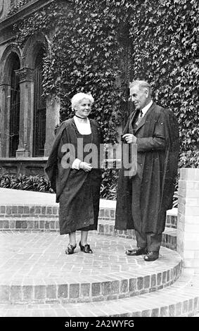 Négatif - East Melbourne, Victoria, vers 1935, un homme et une femme en face de l'enseignant Presbyterian Ladies College. Les deux porter robes académiques Banque D'Images