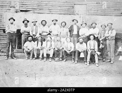 Négatif - Bendigo, Victoria, vers 1895, un groupe de mineurs de la mine de St Mungo. Ils sont debout en face de la chaudière vapeur. Un homme est titulaire d'un chien Banque D'Images