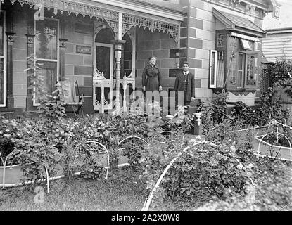 Carrière - Négatif Hill, Bendigo, Victoria, vers 1910, un homme et une femme sur la véranda de leur maison. Il y a un jardin bien entretenu à l'avant de la maison Banque D'Images