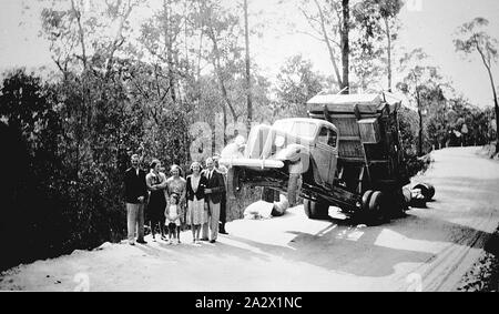 - Négatif Omeo District, Victoria, 1939, un camion de pointe où un déplacement chargement a tiré l'avant du chariot au-dessus du sol. Une partie de la charge est sur le terrain derrière le camion. Un groupe de personnes debout sur la gauche Banque D'Images