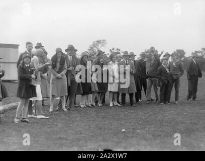 Négatif sur verre - gens de terrain de sport, vers 1930, un noir et blanc, Négatif sur plaque demi doté d''un groupe d'hommes, de femmes et d'enfants debout dans une ligne sur un terrain de sport, probablement en attente d'une race ou de jeu.La provenance de cette image n'est pas clair, mais il est venu de l'entreprise Kodak museum à Coburg. collection de produits, matériel de promotion, des photographies et de la vie professionnelle artefacts recueillis de Kodak Australasia Banque D'Images