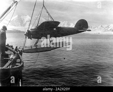 Photographie - Descente Lockheed Vega hydravion de navire, Wilkins Hearst expédition en Antarctique, par George Rayner, Port Lockroy, l'Antarctique, vers 1929, photo ; déchargement avion équipé de flotteurs du bateau, vers 1929. Marqué AVION WILKINS HEARST EXPÉDITION EN ANTARCTIQUE ET LOCKHEED AIRCRAFT CO. LOS ANGELES U.S.A. ET VEGA X3903. Photographie PRISE PAR GEORGE RAYNER EN ANTARCTIQUE Banque D'Images