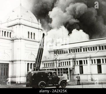 Photographie - Aquarium Incendie, bâtiment d'exposition, Melbourne, 1953, Photographie noir et blanc de l'Aquarium incendie qui a eu lieu le mercredi 28 janvier 1953. La fumée s'échapper de la photographie montre le bâtiment d'exposition avec un camion d'incendie à l'avant. C'est l'une des 959 photos (ou images) de l'Exhibition Building collationnées par l'administration d'exposition comme un volume 10 de l'histoire picturale bâtiment d'exposition couvrant les années 1880 à 1985. L'illustration Banque D'Images