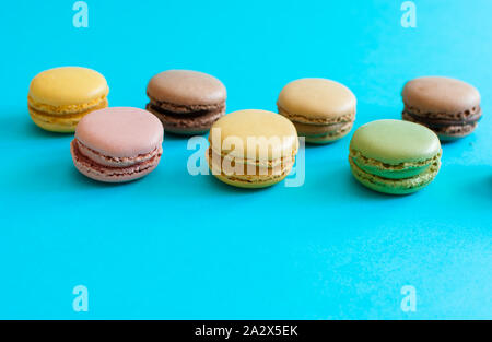 Dessert macarons français colorés sur fond bleu Banque D'Images